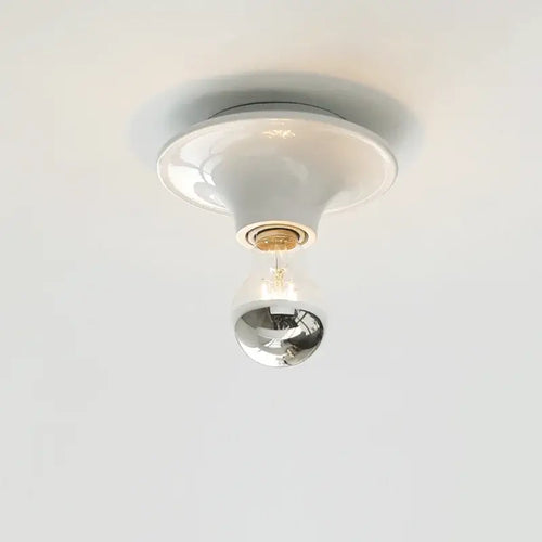 80s revival wall light with UFO-shaped base and silver top bulb, perfect for adding retro charm to modern interiors.
