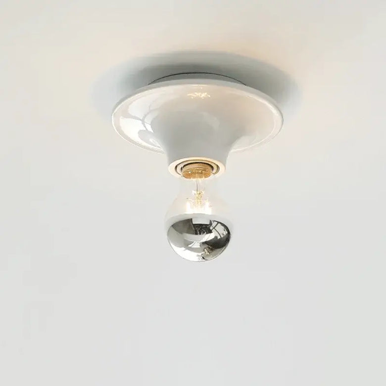 80s revival wall light with UFO-shaped base and silver top bulb, perfect for adding retro charm to modern interiors.