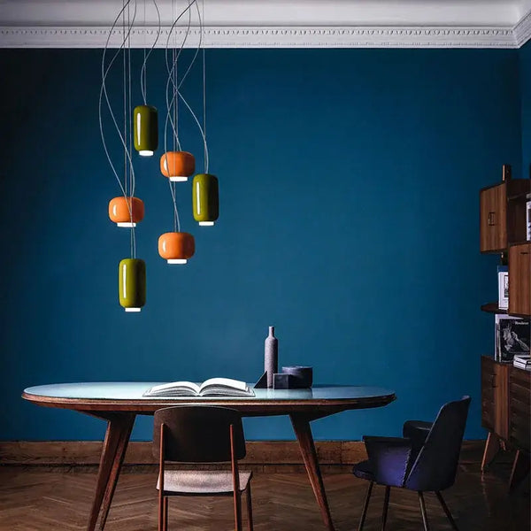 Modern Glass Pendant Light – Italian-Inspired LED Suspension Lamp in green and orange colors above a dining table.