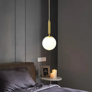 Mid-Century Modern Glass Ball Pendant Light hanging in a stylish bedroom setting with soft lighting.