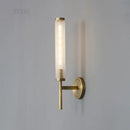Stylish Art Deco Brass Wall Lamp with frosted glass and warm illumination on a wall.