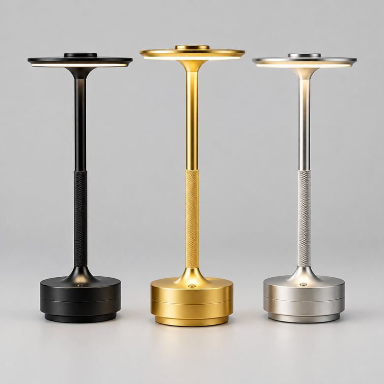 Art Deco cordless disc table lamps in black, gold and silver on a white desk