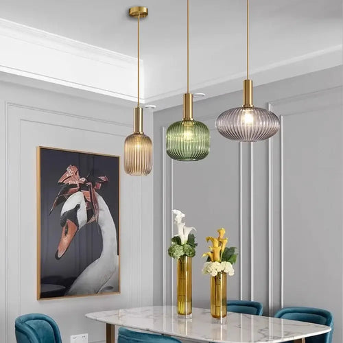Pendant Light: Modern Nordic Glass Hanging Lighting Fixtures over a stylish dining table, featuring green and gold glass shades.