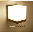 Wood and Frosted Glass Japanese Minimalist Sconces illuminating a wall with a soft nocturnal effect.