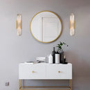 Modern interior featuring Posh Marble & Gold Roman Villa Sconce, round mirror, and stylish white cabinet.
