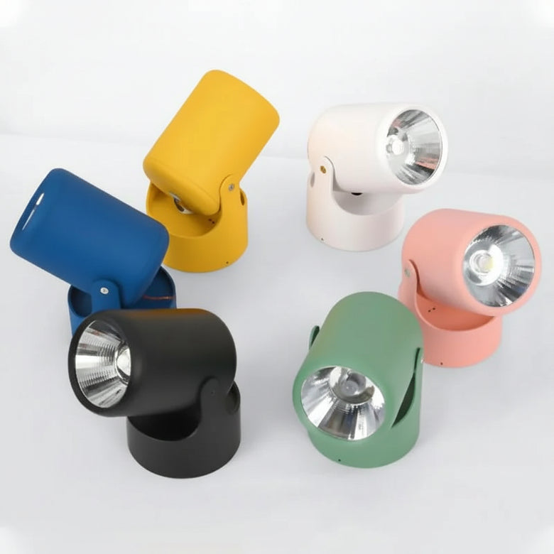 hero Six modern adjustable spotlight lamps in different colors (blue, yellow, white, pink, green, and black) arranged on a light gray background.