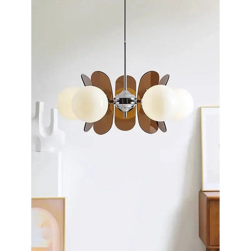 Rare Mid-Century Orange Plexiglass Chandelier: A Unique Vintage Gem showcasing oval orange reflectors and white frosted glass balls.