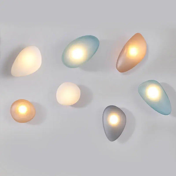 Elegant Frosted Glass Pebble Wall Lamp - Minimalist Nordic Style in various colors and shapes, providing ambient lighting.