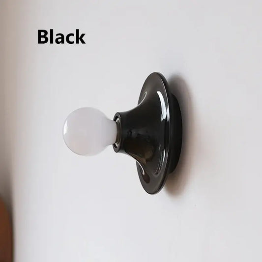 80s revival wall light in black with UFO shape and white bulb, perfect for retro decor.
