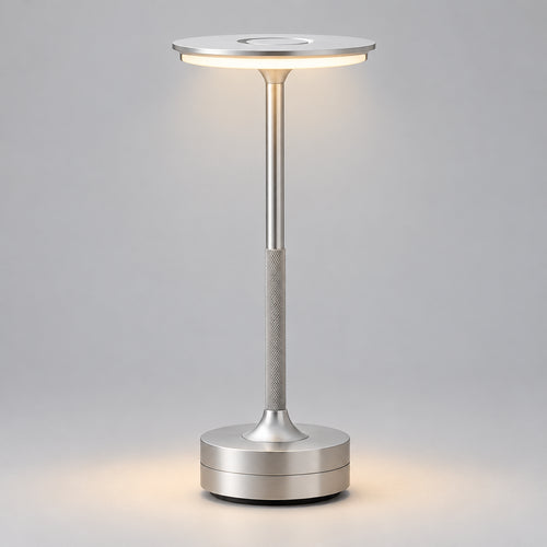 Silver Art Deco cordless disc table lamp on a wooden table