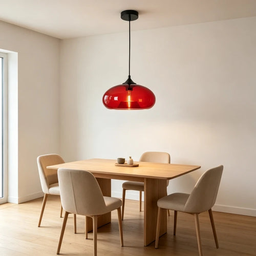 Red glass dome pendant light above a wooden dining table with chairs