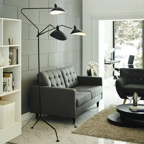 Nordic Designer Tripod Floor Lamp illuminating a modern living room with gray sofa and stylish decor.