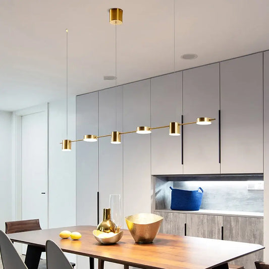Hanging Minimalism Lights illuminating a modern dining area with a sleek golden design and elegant decor.