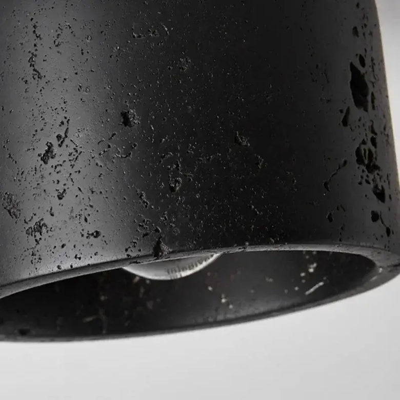 Close-up of the Black Travertine Ceiling Lamp showcasing its textured surface and modern design.