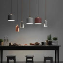 Colourful, modern, metal Danish Light Pendant illuminating a dining table with minimalist decor.