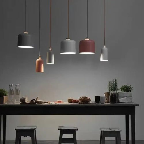 Colourful, modern, metal Danish Light Pendant illuminating a dining table with minimalist decor.