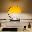 80s USB desk lamp in various colours illuminating a stylish desk with decorative items.