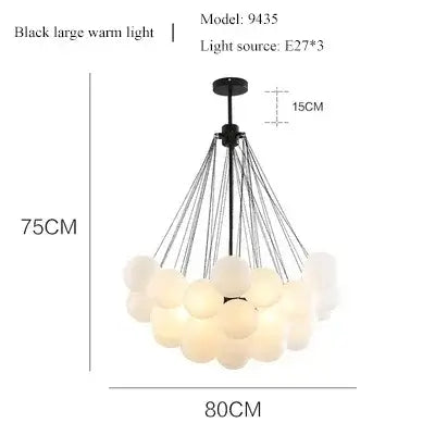 Contemporary Frosted Glass Ball & Gold Chain Chandelier with soft white lights and black fixture.