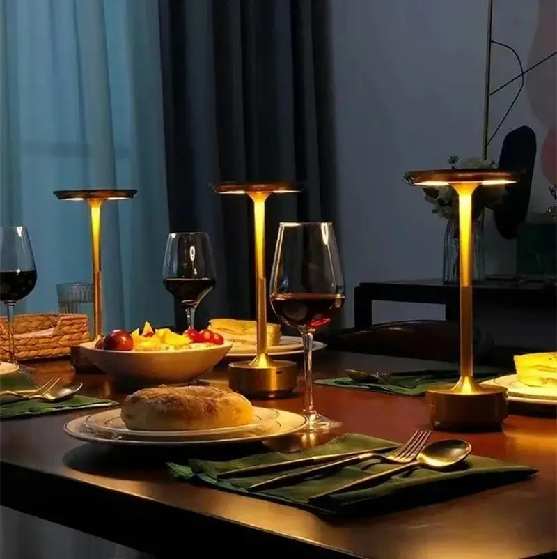 Several Gold cordless table lamps, on a wooden table