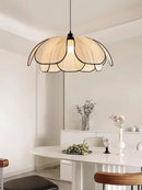 Black and White Rattan Flower Lamp Shade hanging over a modern dining table in a bright, minimalist interior.