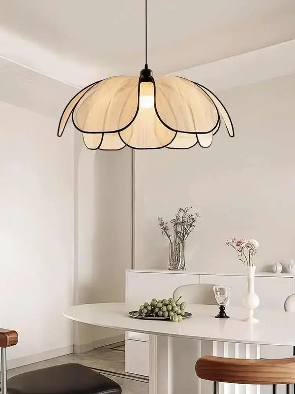 Black and White Rattan Flower Lamp Shade hanging over a modern dining table in a bright, minimalist interior.