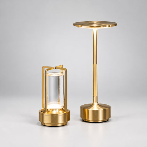Two gold table lamps on a wooden surface with a blurred background