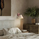 Natural Travertine Stone Wall Lamp – Modern LED Sconce for Bedrooms illuminating a cozy bedroom with modern decor.