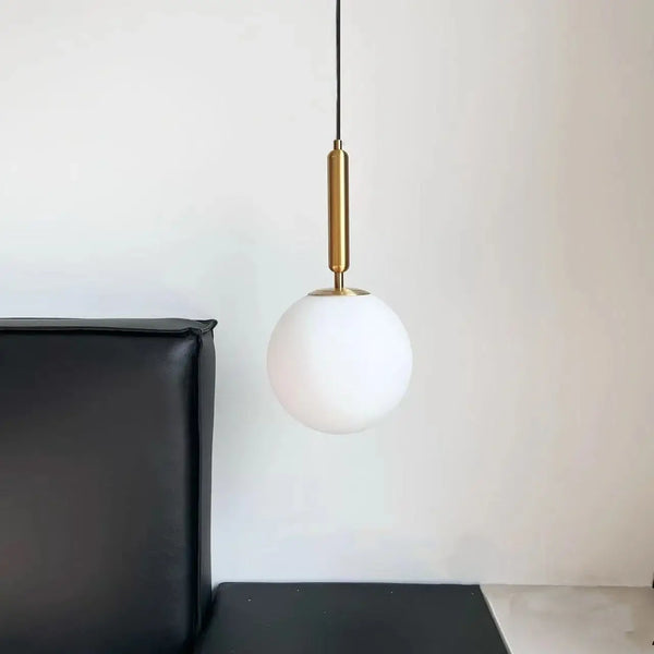 Modern Gold Glass Ball Pendant hanging above a black sofa, adding elegance to contemporary interior decor.