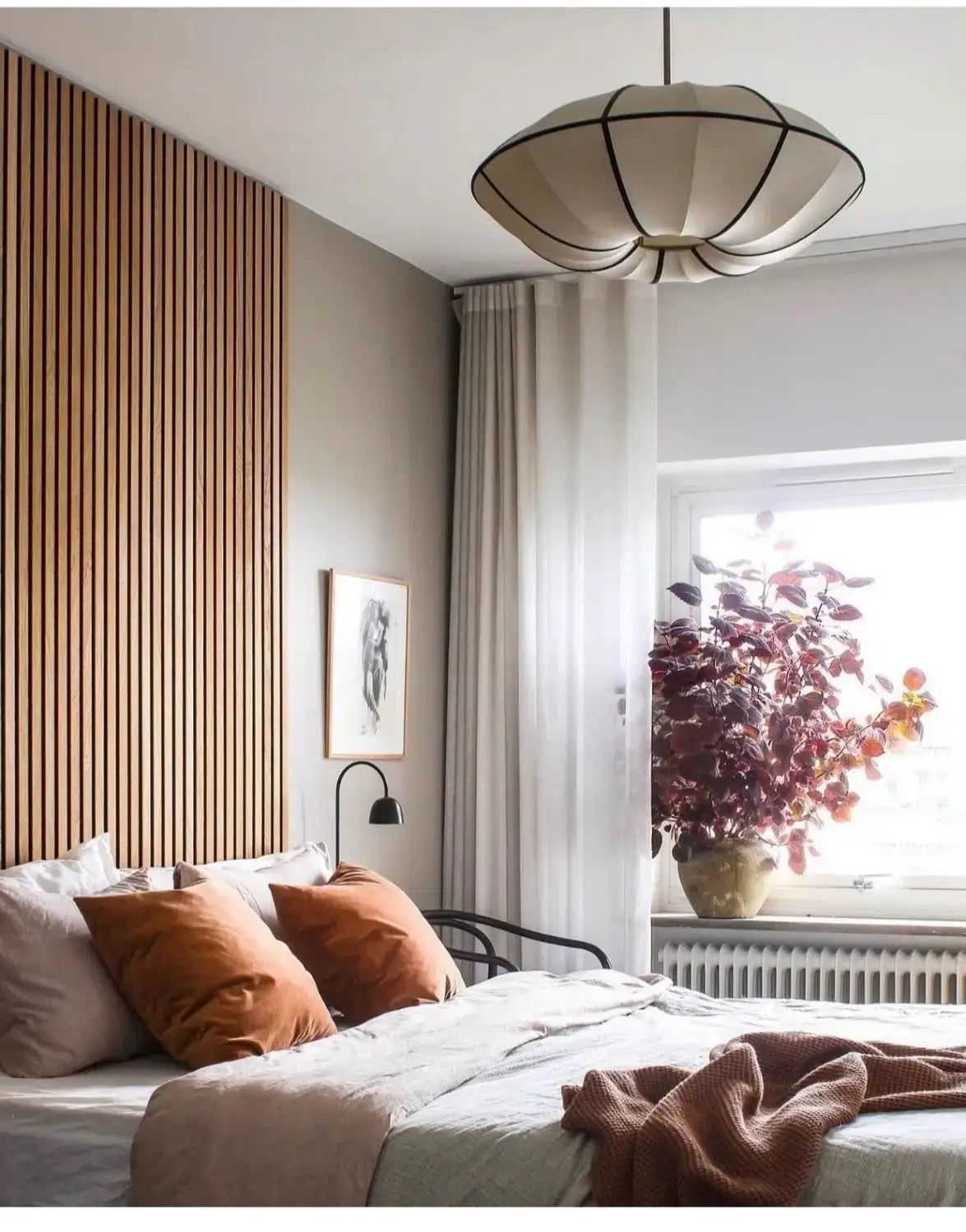 Zen Silk Pendant Light Mid Century Fabric Lantern illuminating a stylish bedroom with warm tones and wooden accents.