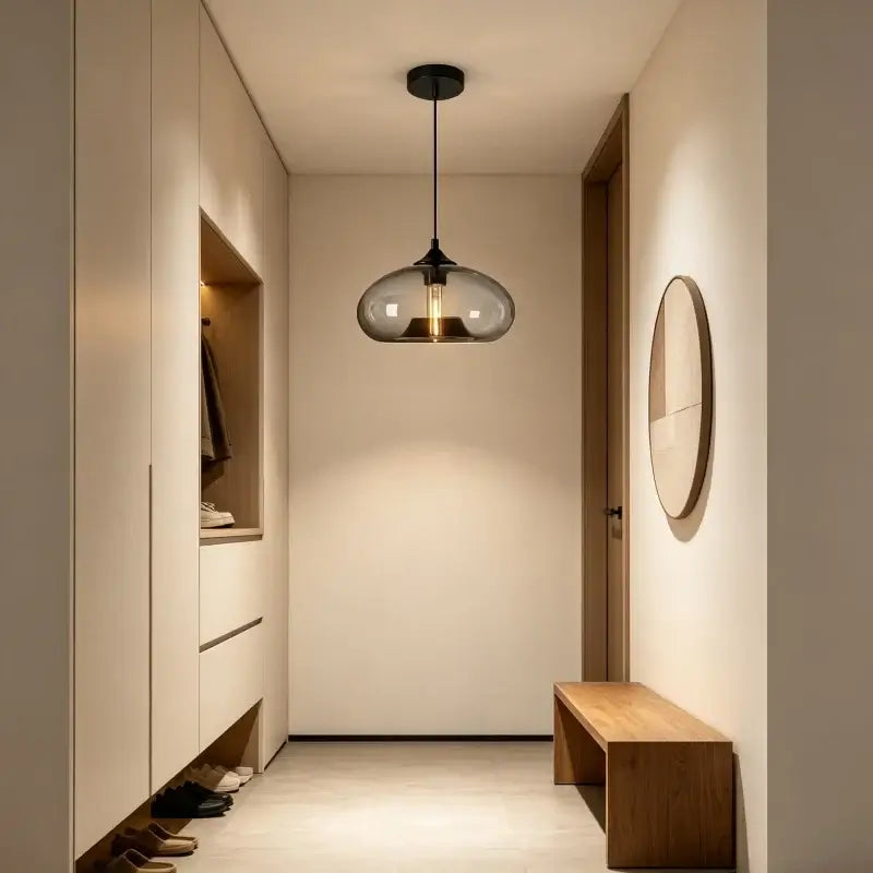 Smoke grey glass dome pendant light in a hallway with a bench