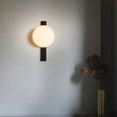 Decorative Lighting Fixture With Milk White Glass Sphere mounted on a wall, casting a warm glow in a stylish interior.