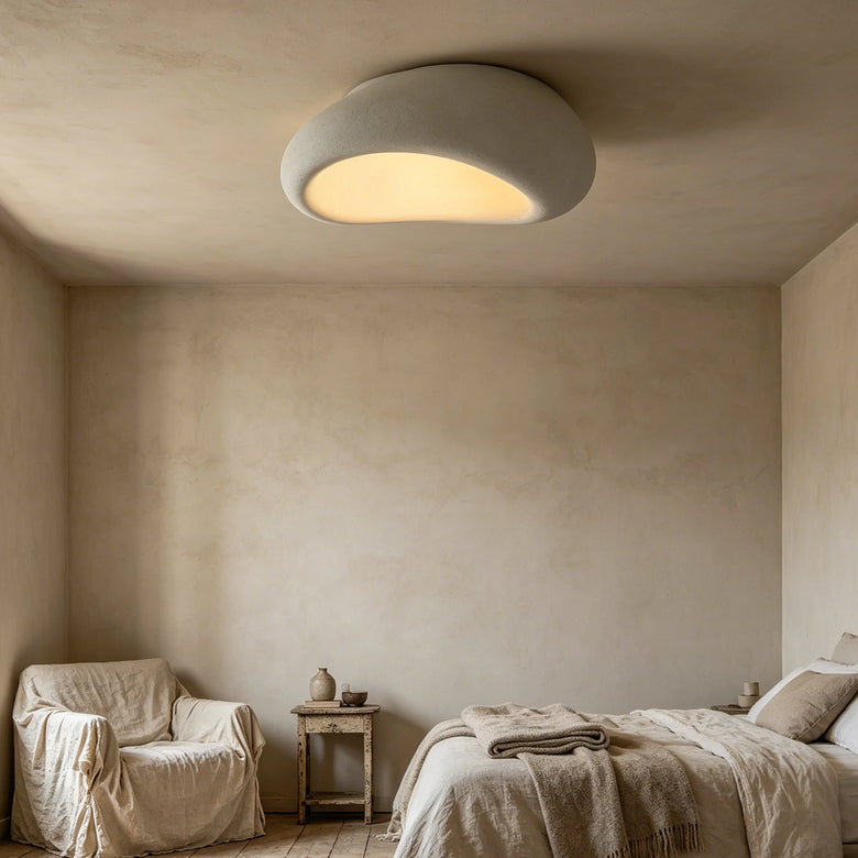Organic stone ceiling light grey white illuminating a minimalist bedroom with soft textures and warm ambiance.