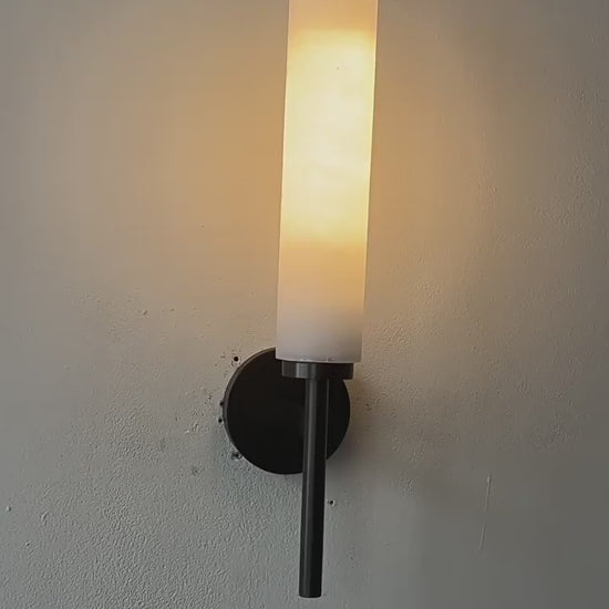 Stylish Art Deco Brass Wall Lamp with frosted glass, emitting warm glow, perfect for elegant interiors in bedrooms, living rooms, and studies.