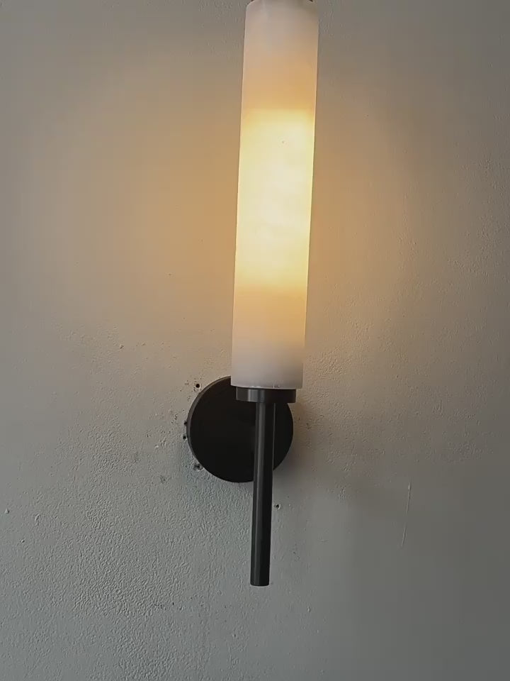 Stylish Art Deco Brass Wall Lamp with frosted glass, emitting warm glow, perfect for elegant interiors in bedrooms, living rooms, and studies.