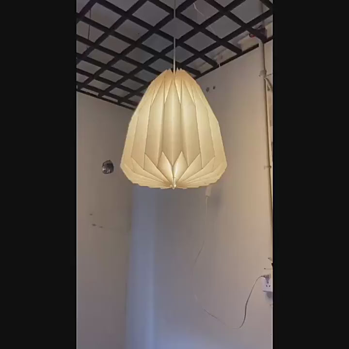 Elegant Origami-Inspired Paper Lantern hanging indoors with soft illumination, showcasing minimalist design and creative folding patterns.